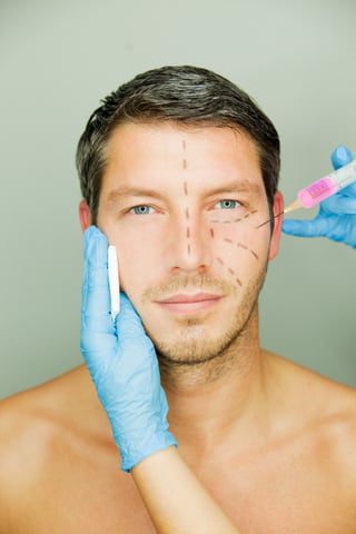 handsome male face marked up for cosmetic surgery
